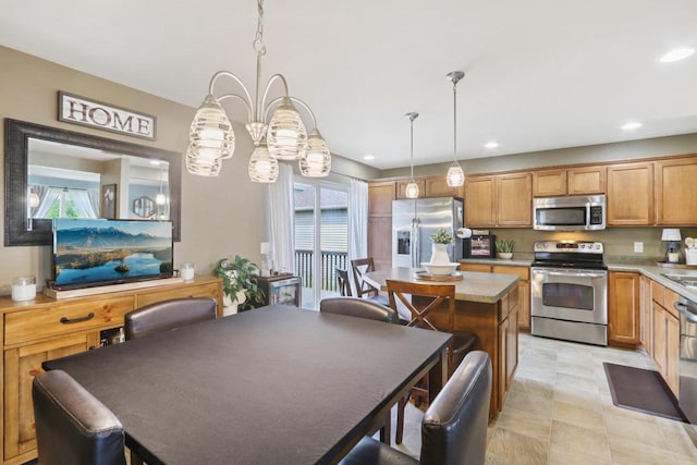 7042 Littlemore Dr, Madison, WI 53718 - kitchen featuring appliances with stainless steel finishes, light countertops, recessed lighting, decorative light fixtures, and a center island