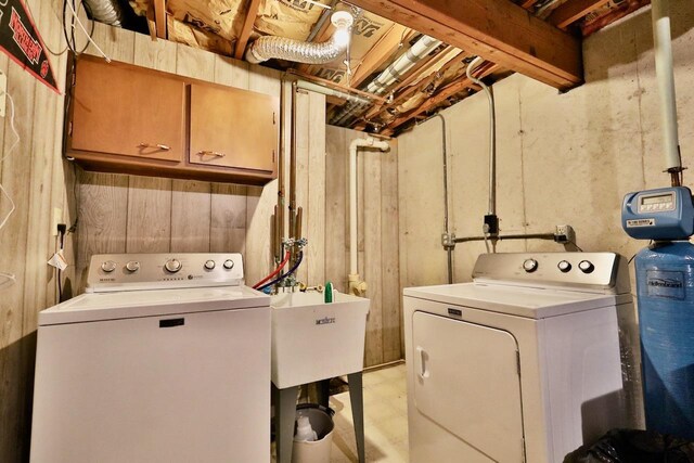 2413 Ravenswood Rd, Madison, WI 53711 - washroom featuring washing machine and dryer, cabinet space, and light flooring