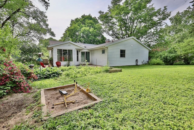 2413 Ravenswood Rd, Madison, WI 53711 - rear view of house with a lawn, a chimney, and a vegetable garden