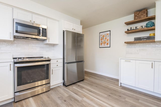 8725 N Fielding Rd, Bayside, WI 53217 - kitchen featuring stainless steel appliances, light wood finished floors, light countertops, tasteful backsplash, and white cabinetry