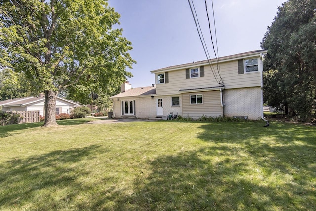8725 N Fielding Rd, Bayside, WI 53217 - rear view of house featuring brick siding, a lawn, a patio, and a chimney