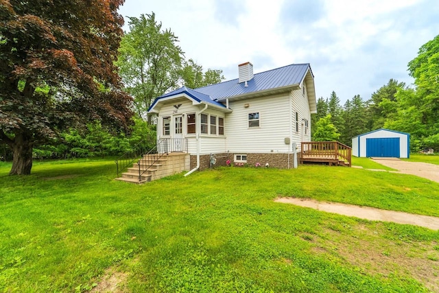 2941 Plover Rd, Wisconsin Rapids, WI 54494 - rear view of house with a chimney, an outdoor structure, a detached garage, and a lawn