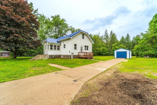 2941 Plover Rd, Wisconsin Rapids, WI 54494 - rear view of house with driveway, an outdoor structure, a chimney, and a yard