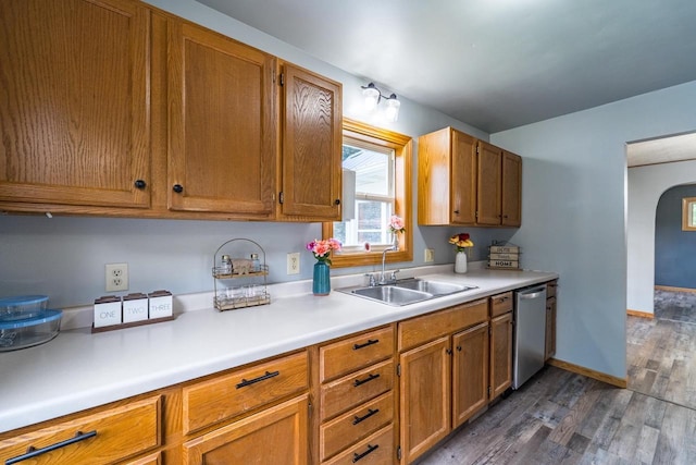 2941 Plover Rd, Wisconsin Rapids, WI 54494 - kitchen with stainless steel dishwasher, arched walkways, dark wood finished floors, light countertops, and brown cabinetry