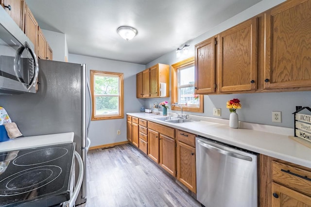 2941 Plover Rd, Wisconsin Rapids, WI 54494 - kitchen featuring appliances with stainless steel finishes, light wood-style flooring, brown cabinets, and light countertops