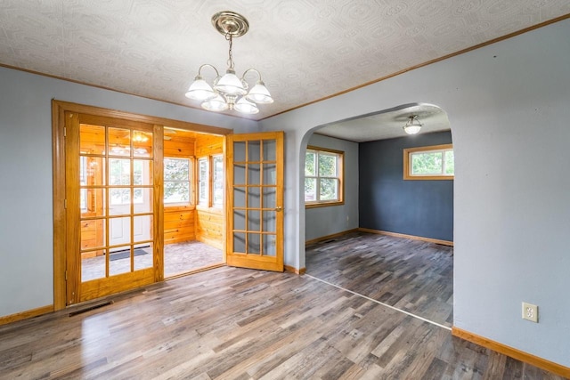 2941 Plover Rd, Wisconsin Rapids, WI 54494 - empty room featuring arched walkways, ornamental molding, wood finished floors, and a chandelier