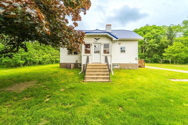 2941 Plover Rd, Wisconsin Rapids, WI 54494 - back of property with a chimney, a yard, and a metal roof