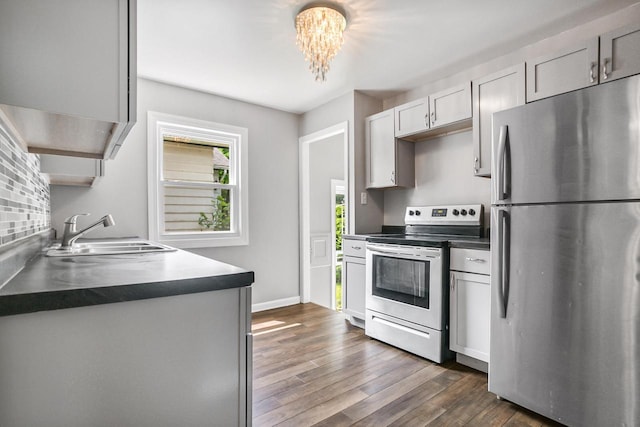 4636 N 19th St, Milwaukee, WI 53209 - kitchen with stainless steel appliances, dark countertops, dark wood-style floors, and a chandelier