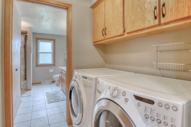 W227N2527 Meadowood Ln, Waukesha, WI 53186 - washroom featuring washer and dryer, light tile patterned flooring, and cabinet space