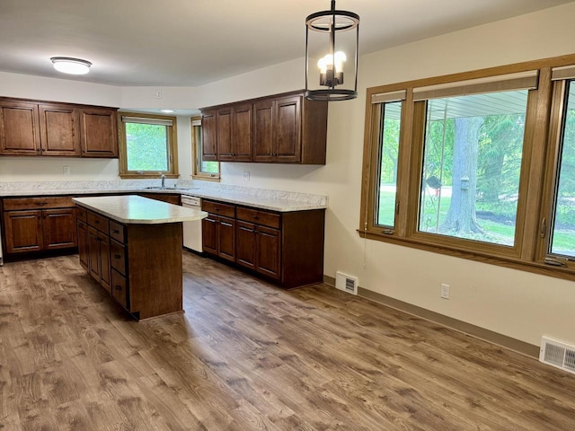 7720 W Honey Creek Pkwy, West Allis, WI 53219 - kitchen featuring stainless steel dishwasher, light countertops, wood finished floors, and a center island