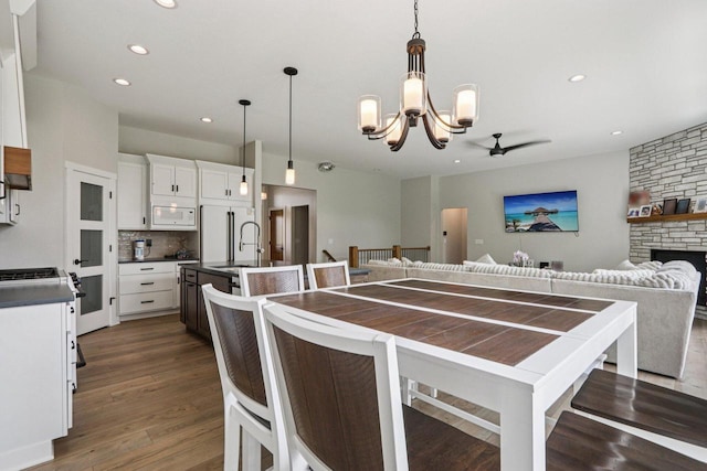 2322 Kae Ct, Mount Pleasant, WI 53406 - kitchen with white microwave, dark countertops, ceiling fan, decorative backsplash, and dark wood-type flooring