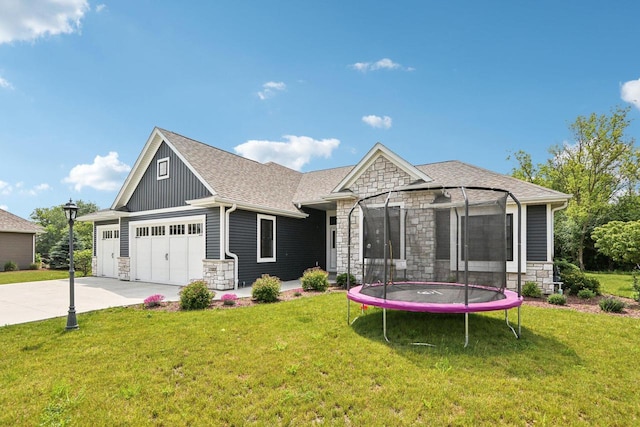 2322 Kae Ct, Mount Pleasant, WI 53406 - view of front of property with stone siding, a trampoline, and a front lawn
