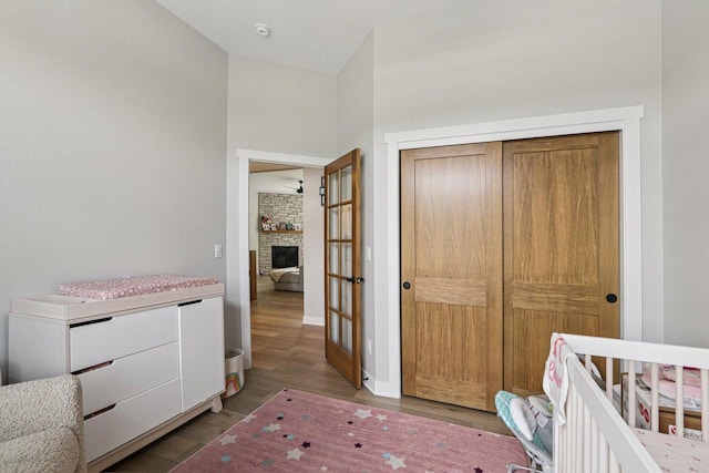 2322 Kae Ct, Mount Pleasant, WI 53406 - bedroom featuring wood finished floors, a closet, a stone fireplace, and a nursery area