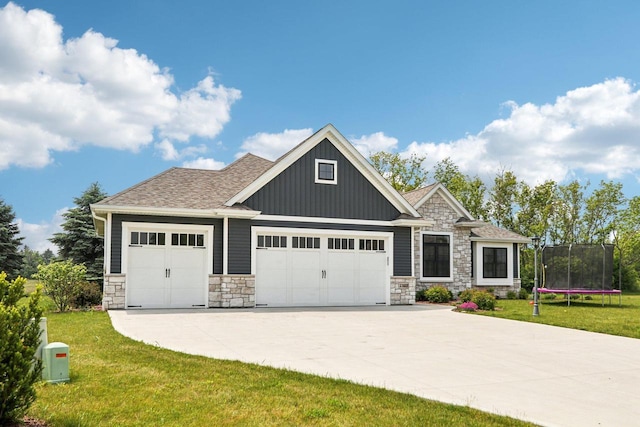 2322 Kae Ct, Mount Pleasant, WI 53406 - craftsman inspired home featuring a trampoline, stone siding, an attached garage, board and batten siding, and a front yard
