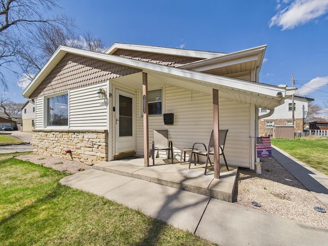 10534 W Stark St, Milwaukee, WI 53225 - rear view of property featuring covered porch, stone siding, and a yard
