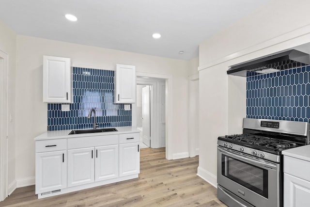 4423 N 30th St Unit 4425, Milwaukee, WI 53209 - kitchen with gas stove, backsplash, premium range hood, light countertops, and white cabinets