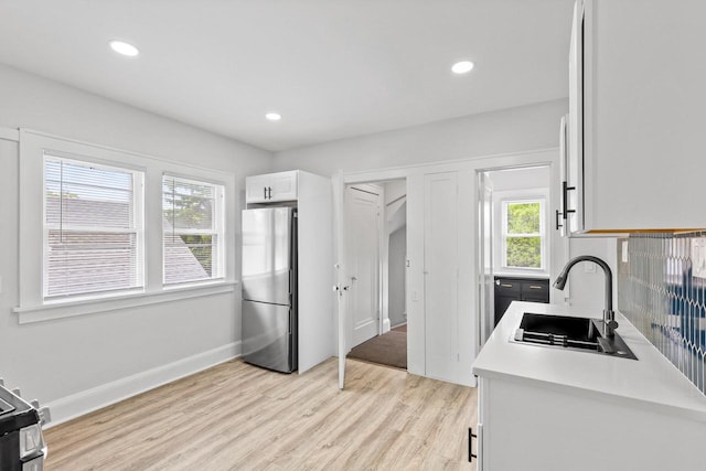 4423 N 30th St Unit 4425, Milwaukee, WI 53209 - kitchen featuring freestanding refrigerator, light wood finished floors, light countertops, white cabinetry, and recessed lighting