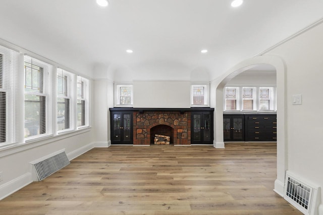 4423 N 30th St Unit 4425, Milwaukee, WI 53209 - unfurnished living room featuring recessed lighting, a stone fireplace, wood finished floors, and arched walkways
