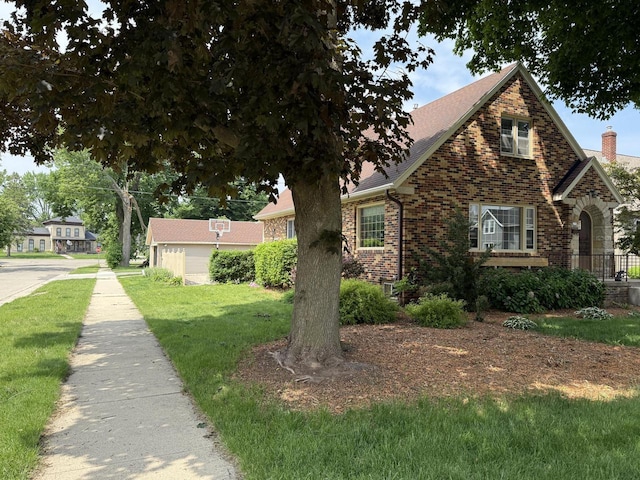 472 Orchard St, Burlington, WI 53105 - view of front facade featuring brick siding, a front yard, a shingled roof, and a chimney