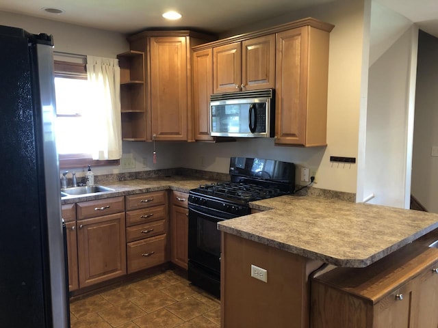 472 Orchard St, Burlington, WI 53105 - kitchen with stainless steel microwave, black range with gas stovetop, a peninsula, freestanding refrigerator, and open shelves