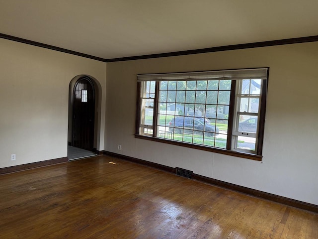 472 Orchard St, Burlington, WI 53105 - empty room with arched walkways, dark wood-type flooring, and crown molding