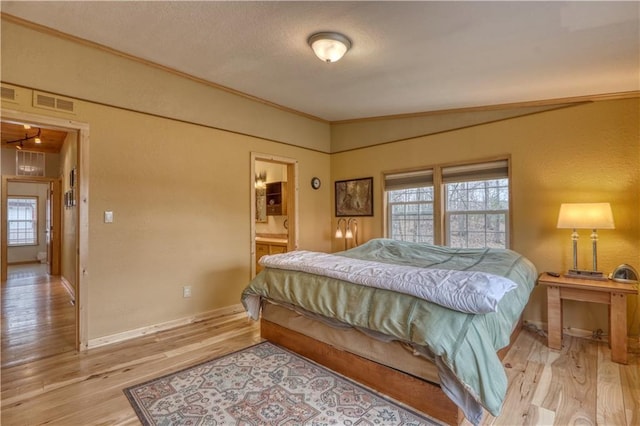 7766 Thunder Point Rd, Hayward, WI 54843 - bedroom with a textured wall, light wood-style floors, crown molding, a textured ceiling, and ensuite bath