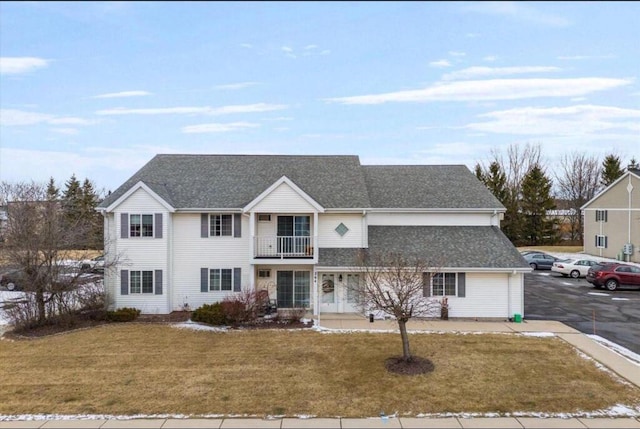 264 Minz Park Cir Unit 4, West Bend, WI 53095 - traditional home with a balcony, a front lawn, uncovered parking, and a shingled roof