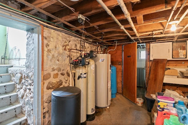 N2485 County Road Ii, Columbus, WI 53925 - below grade area featuring a water softener system, gas water heater, a water pressure tank, and radiator heating unit
