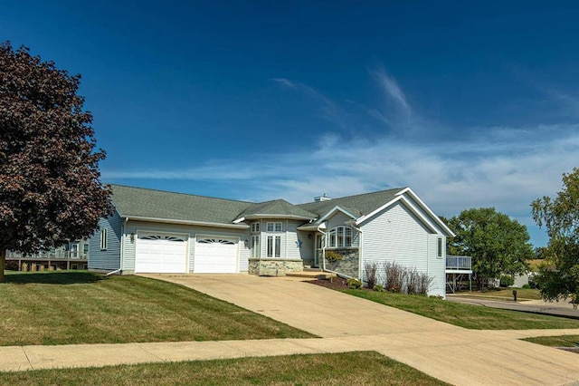 1227 N 3rd St, Monroe, WI 53566 - view of front of house with an attached garage, a front yard, concrete driveway, and stone siding