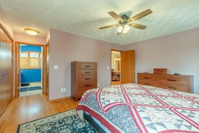 1227 N 3rd St, Monroe, WI 53566 - bedroom with light wood-type flooring, a chandelier, ceiling fan, and a closet