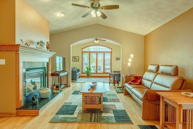 1227 N 3rd St, Monroe, WI 53566 - living room with arched walkways, ceiling fan, light wood finished floors, vaulted ceiling, and a glass covered fireplace