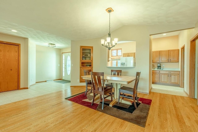 1227 N 3rd St, Monroe, WI 53566 - dining room featuring a chandelier, light wood finished floors, and vaulted ceiling