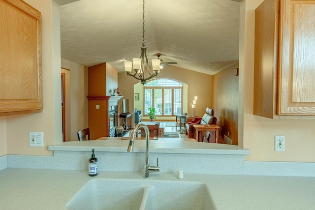 1227 N 3rd St, Monroe, WI 53566 - kitchen featuring light brown cabinets, a glass covered fireplace, light countertops, vaulted ceiling, and a chandelier