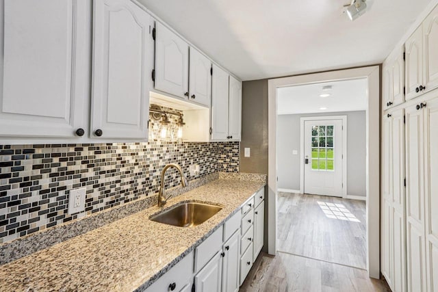 1383 Range Trl, Verona, WI 53593 - kitchen featuring decorative backsplash, white cabinetry, light stone counters, and light wood-style floors