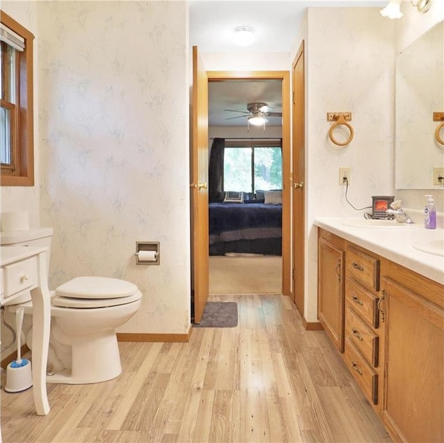 112 S 3rd St, Luck, WI 54853 - ensuite bathroom featuring wood finished floors, wallpapered walls, vanity, and a ceiling fan