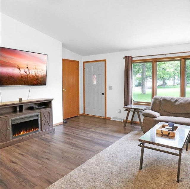 112 S 3rd St, Luck, WI 54853 - living area featuring wood finished floors, lofted ceiling, and a warm lit fireplace