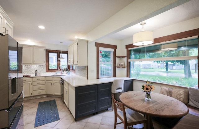 3154 N 82nd St, Milwaukee, WI 53222 - kitchen featuring stainless steel appliances, light countertops, tasteful backsplash, a peninsula, and decorative light fixtures