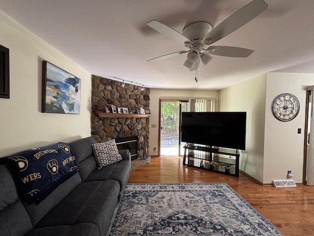 N34W23849 Grace Ave Unit C, Pewaukee, WI 53072 - living room featuring ceiling fan, wood finished floors, and a stone fireplace