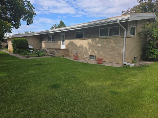 230 Gilbertson St, Markesan, WI 53946 - back of house with a lawn and brick siding
