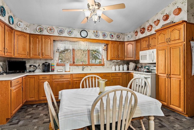 230 Gilbertson St, Markesan, WI 53946 - kitchen featuring white appliances, wallpapered walls, brown cabinets, ceiling fan, and light countertops