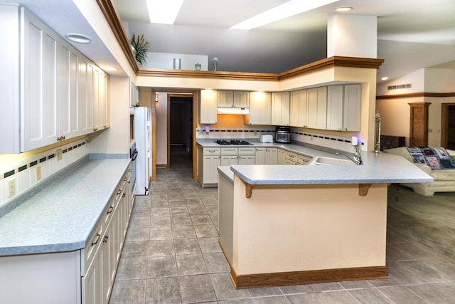 3381 S Highpointe Dr, New Berlin, WI 53151 - kitchen featuring black gas stovetop, backsplash, a breakfast bar, under cabinet range hood, and recessed lighting