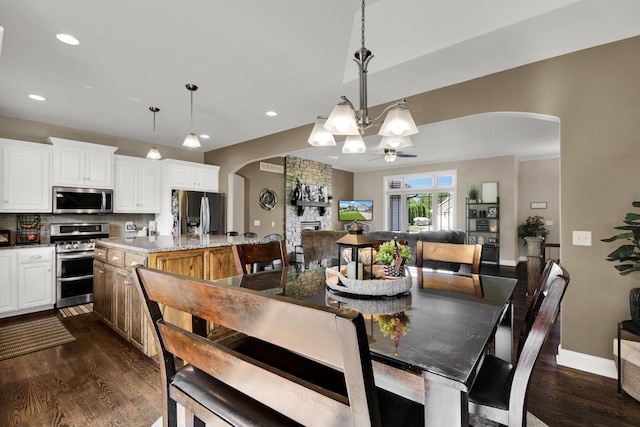 1395 American Eagle Dr, Slinger, WI 53086 - dining area with arched walkways, a chandelier, dark wood finished floors, and recessed lighting