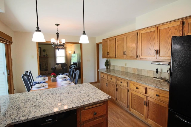 1000 Ridge Rd, Waukesha, WI 53186 - kitchen with black appliances, light wood-style floors, brown cabinetry, and a chandelier