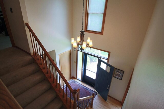 1000 Ridge Rd, Waukesha, WI 53186 - foyer entrance featuring a chandelier, a high ceiling, stairs, and light wood-style flooring