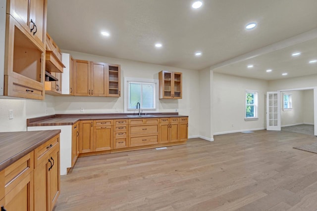 3124 N 29th St, Milwaukee, WI 53216 - kitchen with glass insert cabinets, light wood-style flooring, dark countertops, and recessed lighting