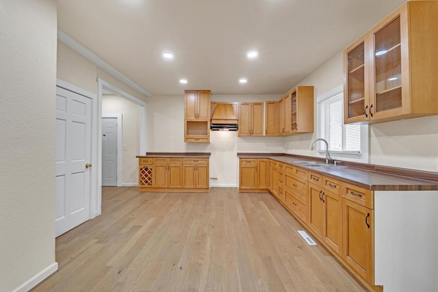 3124 N 29th St, Milwaukee, WI 53216 - kitchen with light wood-style floors, glass insert cabinets, recessed lighting, and dark countertops