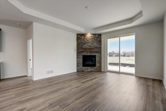 516 Hickory Hollow Rd Unit 0402, Waterford, WI 53185 - unfurnished living room featuring a tray ceiling, wood finished floors, and a fireplace