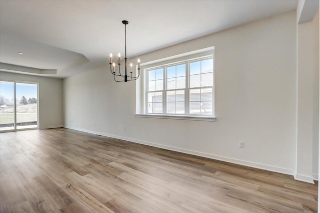516 Hickory Hollow Rd Unit 0402, Waterford, WI 53185 - spare room featuring a chandelier, wood finished floors, and a raised ceiling