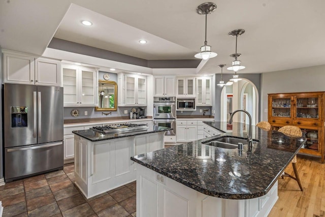 N66W38493 N Woodlake Cir, Oconomowoc, WI 53066 - kitchen featuring appliances with stainless steel finishes, a large island, recessed lighting, white cabinetry, and glass insert cabinets