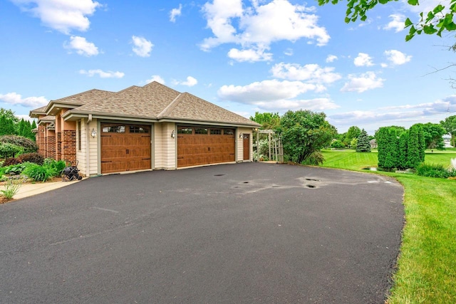 N66W38493 N Woodlake Cir, Oconomowoc, WI 53066 - view of property exterior with an attached garage, driveway, and a lawn